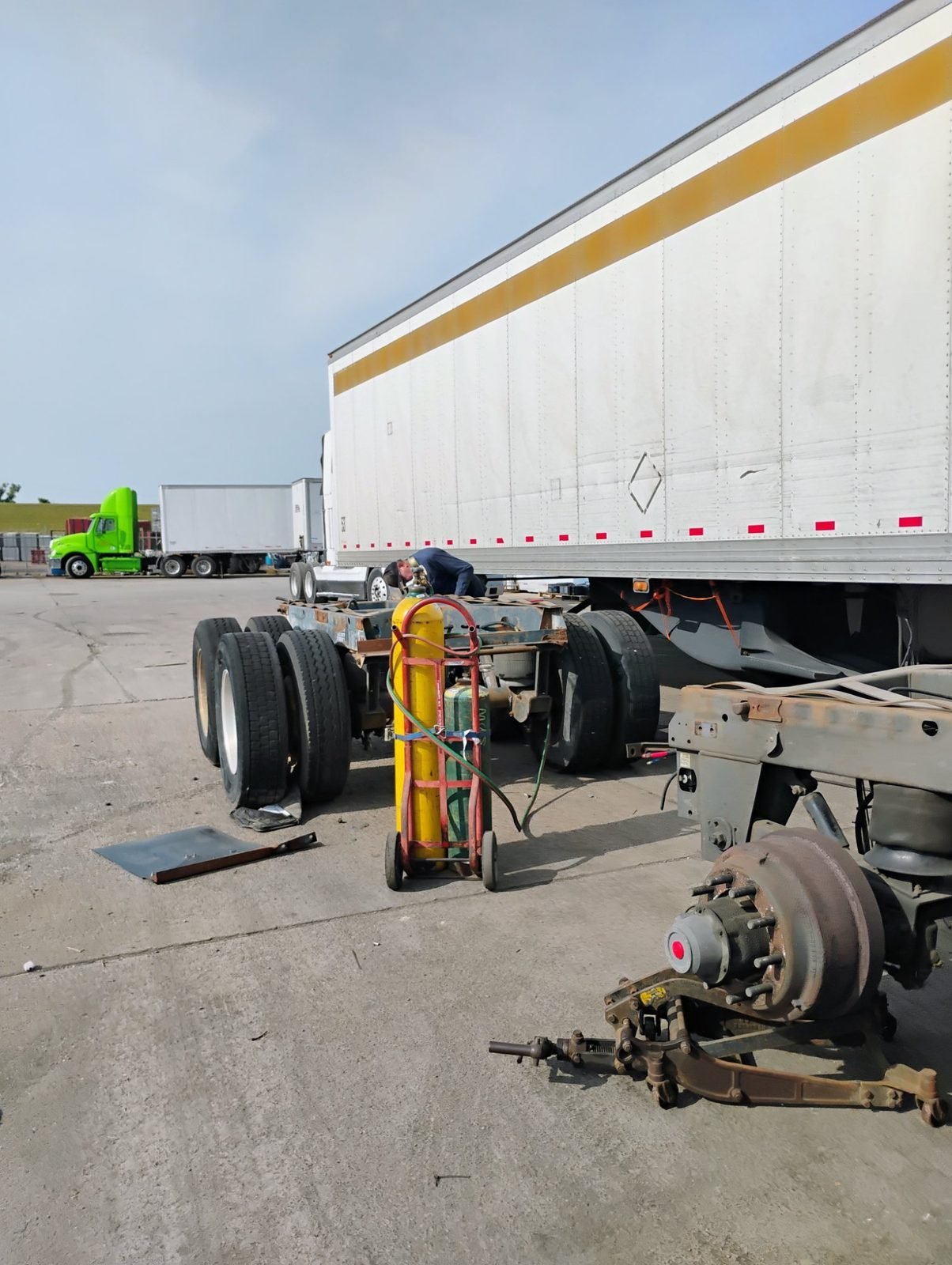 Trailer dolly with wheel-end removed and welding cylinders during trailer repair in Dallas