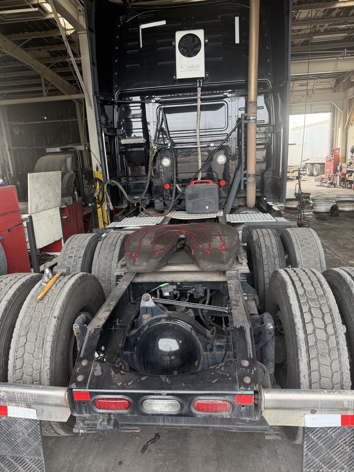 Rear axle, fifth wheel area and tail lights of a semi truck in the Bawa’s shop in Dallas