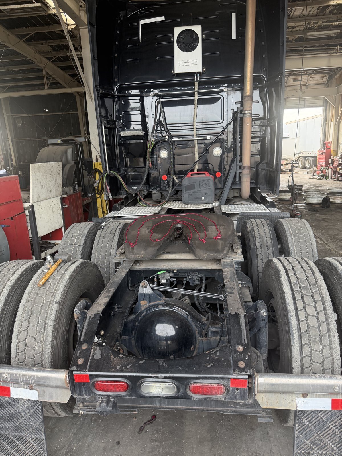 Rear of a semi truck in the Bawa’s shop showing the frame, fifth wheel area and exhaust stack
