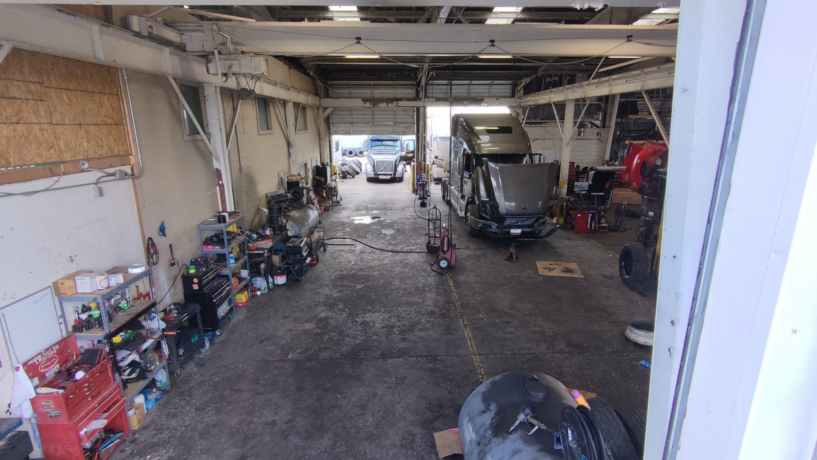 Inside the truck repair bay at Bawa’s Truck & Trailer Repair in Dallas with a tractor on stands