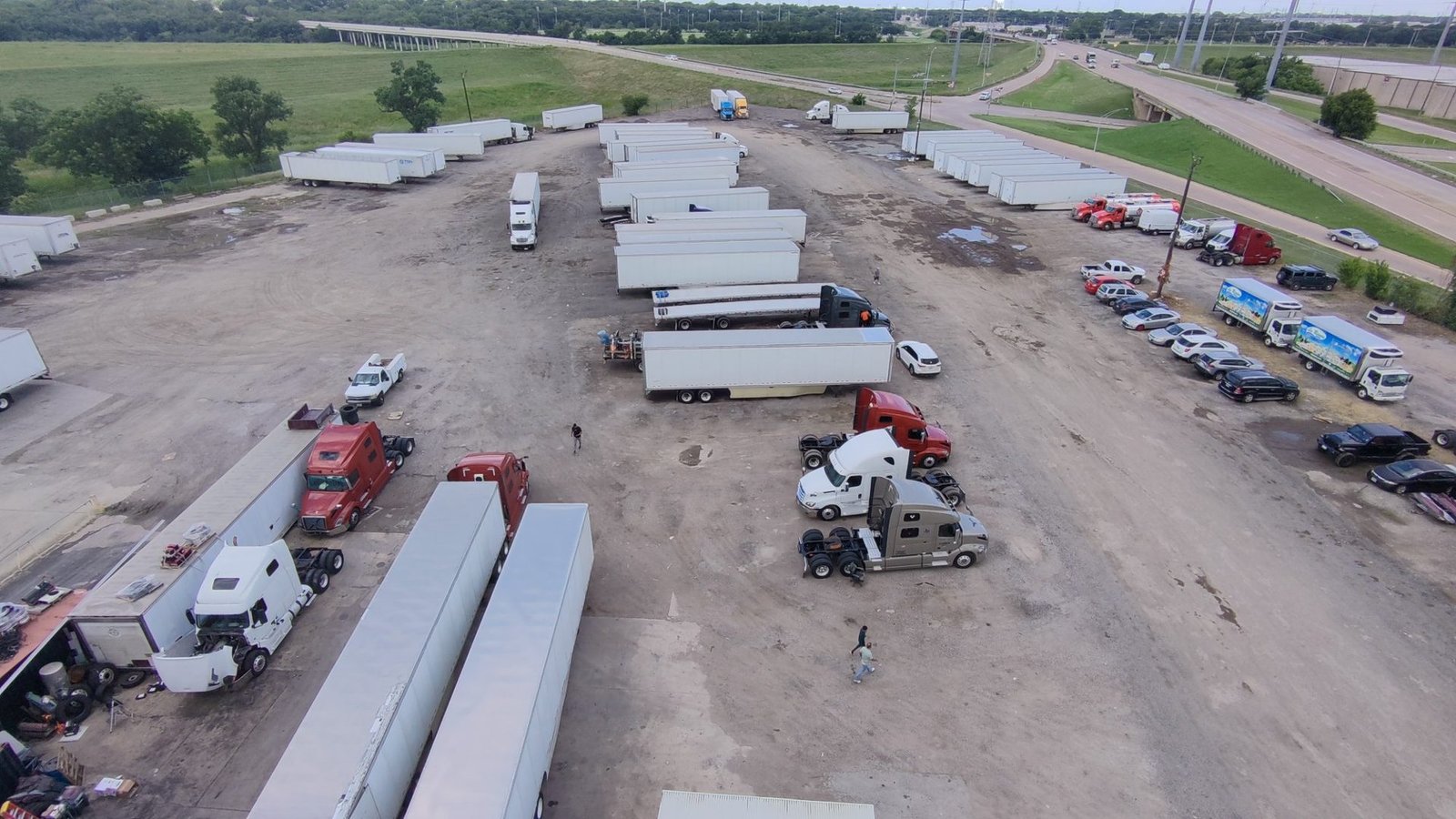 Yard at Bawa’s Truck & Trailer Repair in Dallas with trailers and tractors parked beside the highway