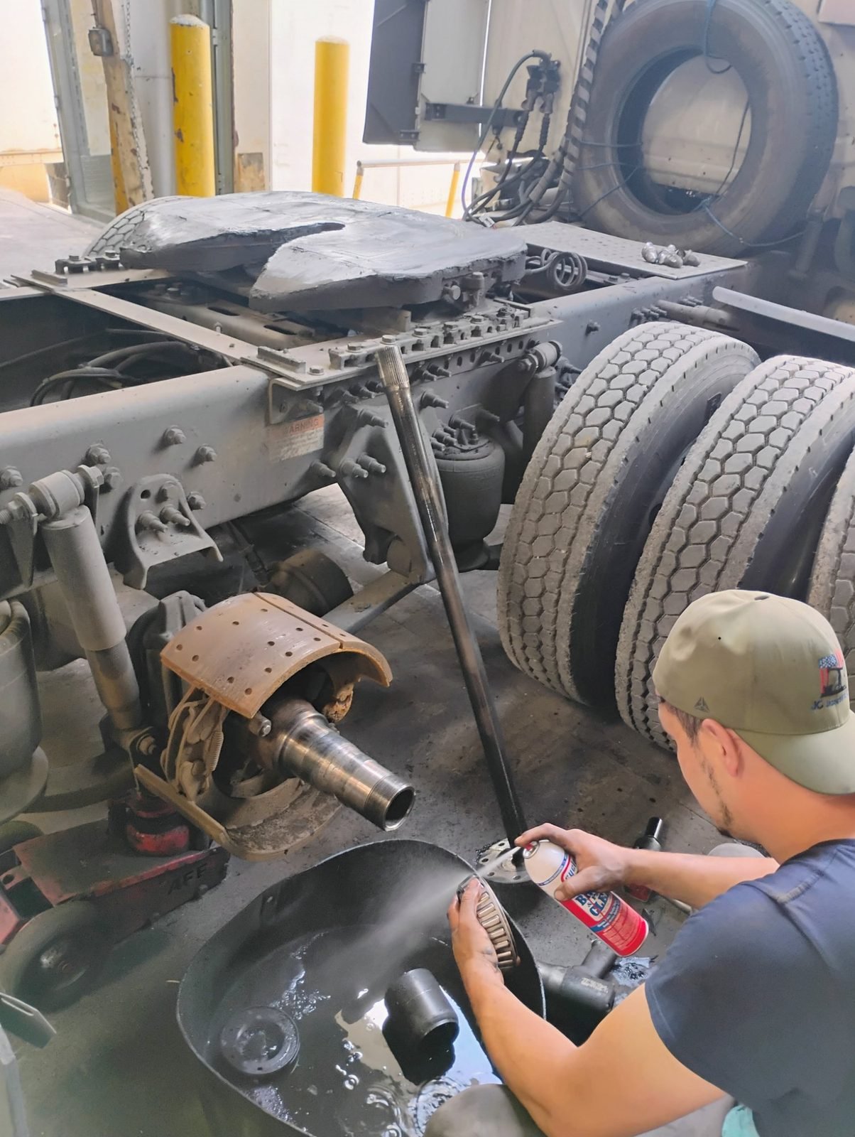 Mechanic cleaning a tapered wheel bearing during axle service at Bawa’s in Dallas